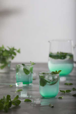 Glass of cold water with fresh mint leaves and ice cubesの写真素材