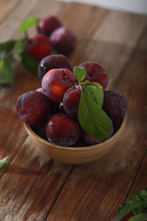 Fresh plum. Harvest. Autumn harvest. Blue plums. Plums on a wooden surface. Fresh plums on wooden table background.の写真素材