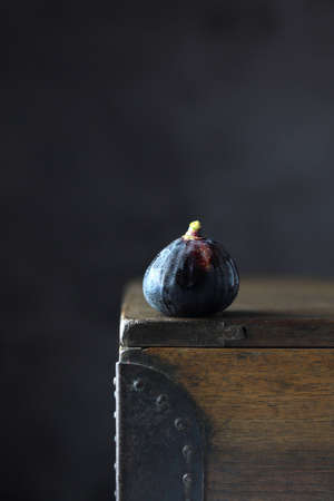 Black fresh fig on wooden box on dark background. Copy spaceの写真素材