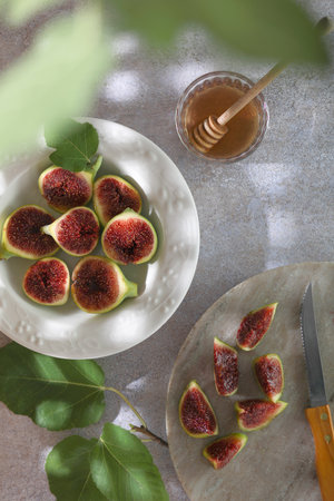 Plate with fresh green figs on plate and honey on gray background.の写真素材