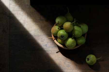 Bowl with ripe pears on wooden table. Space for textの写真素材