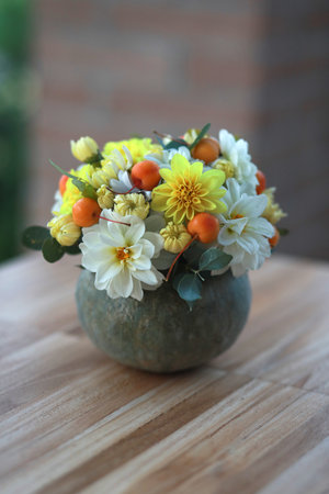 Beautiful autumn composition in pumpkin on table. Thanksgiving centerpiece - bouquet of flowers in the pumpkin.の写真素材