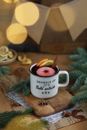 Hot mulled red wine with spices and fruits on a wooden rustic background. Christmas decoration and cup of hot wine.の写真素材