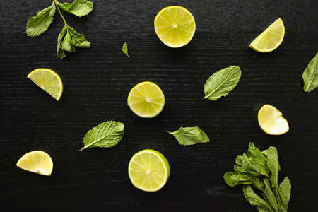 Fresh home-made lemonade ingredients: lemon, lime and mint on black background laying on the tableの写真素材