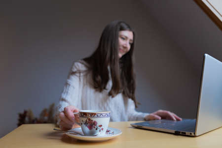 A female hand holding a cup whilst workingの写真素材