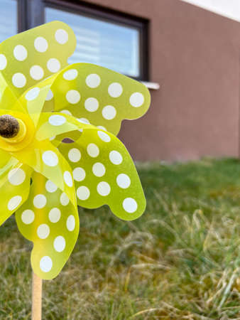 Yellow pinwheel outside with houses in the backgroundの写真素材