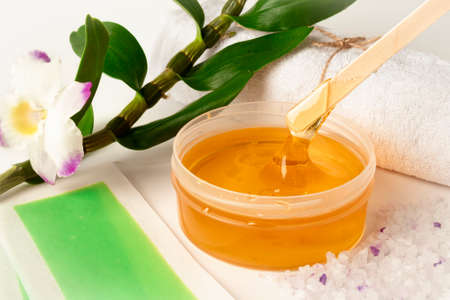 Sugar or wax paste in a bowl with wooden stickの写真素材