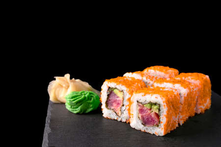 California Tuna Roll In Orange Tobiko Roe Isolated On Black Background.の写真素材