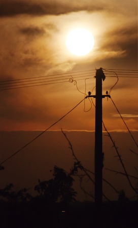 Electric pole against a cloudy sky at dawn