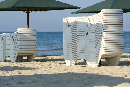 Stacked chaise lounges for tourists on the morning beach.の写真素材