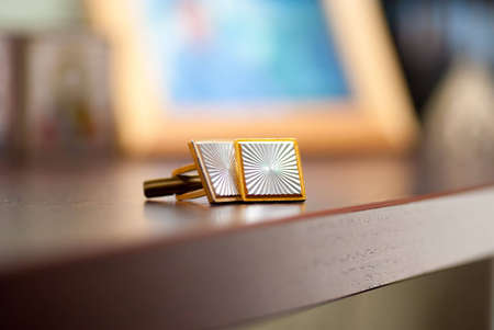 Cufflinks lying on a wooden table