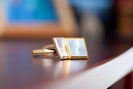 Cufflinks lying on a wooden tableの写真素材