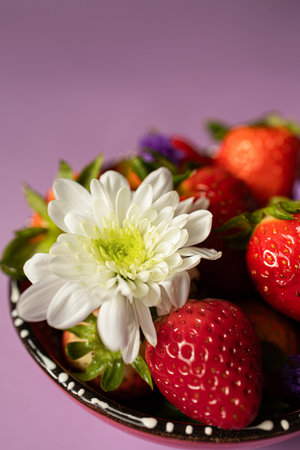 Fresh strawberries in a bowl with a white flowerの写真素材
