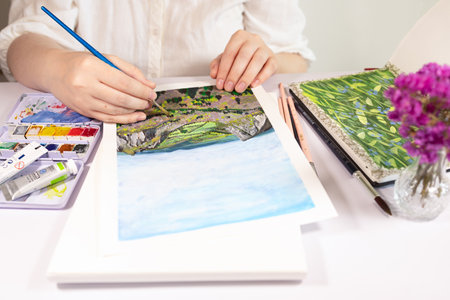 A woman painting with aquarelle and gouache