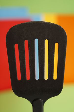 a  big spoon with holes in a simple colorful backgroundの写真素材