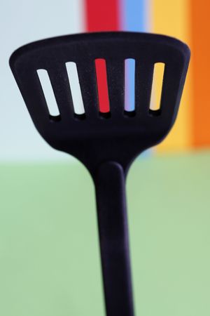 a big spoon with holes in a simple colorful backgroundの写真素材