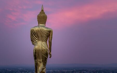Golden Buddha standing on a mountain Wat Phra That Khao Noi during sunset. in, Nan, Thailandの写真素材