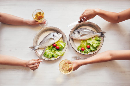 Fish on plates. Top view for dinner and hands.の写真素材