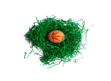 Easter egg with cannabis leaf print. Egg in green nest