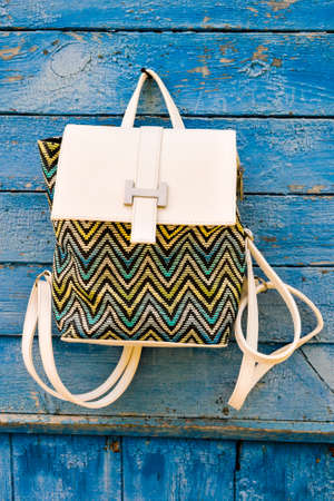 backpack hanging on a blue wooden wallの写真素材