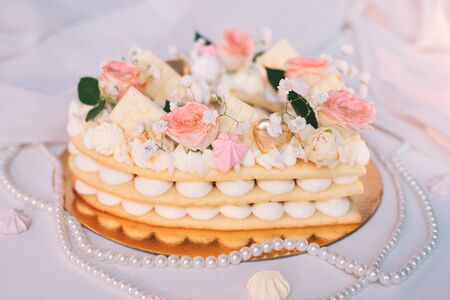 Cake in the form of a heart with layers of white cream with a decoration of fresh flowers on top for Valentine's Day.のeditorial素材