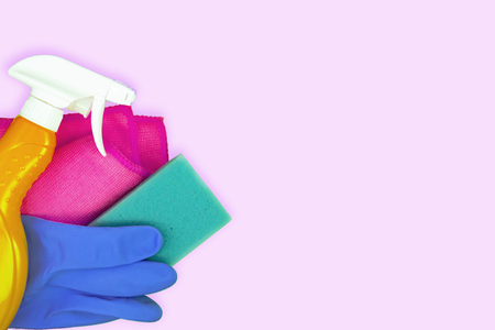 Colorful cleaning set for different surfaces in kitchen, bathroom and other rooms. Empty place for text on light pink background. Cleaning service concept. Early spring regular clean up. Top view.の写真素材