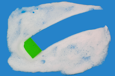 Sponge washes foam on a blue background. Copy space. Top view.の写真素材