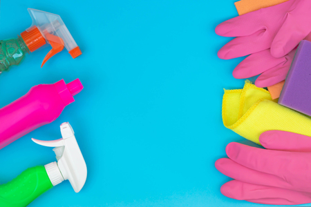 Colorful cleaning set for different surfaces in kitchen, bathroom and other rooms. Empty place for text on blue background. Cleaning service concept. Early spring regular clean up. Top view.の写真素材