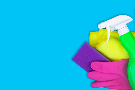 Colorful cleaning set for different surfaces in kitchen, bathroom and other rooms. Empty place for text on blue background. Cleaning service concept. Early spring regular clean up. Top view.の写真素材