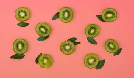 Colorful fruit pattern of fresh kiwi slices on pink background. From top viewの写真素材