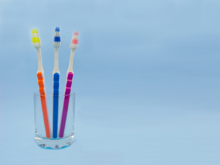 Toothbrushes in a glass, blue background. Copy spaceの写真素材