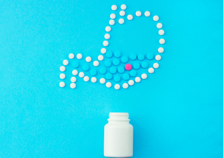 Stomach made of white pills with some red and blue pills inside.の写真素材