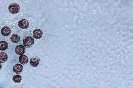 Ripe blueberry berries in blue water with air bubbles. Top view. Wallpapersの写真素材