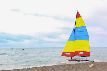 Colorful sailing boat on the european beach on a cloudy dayの写真素材