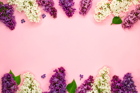 Beautiful floral frame of white, purple and violet lilac flowers on light pink background. Flat lay. Top view. Copy space. Summer romantic concept.の写真素材