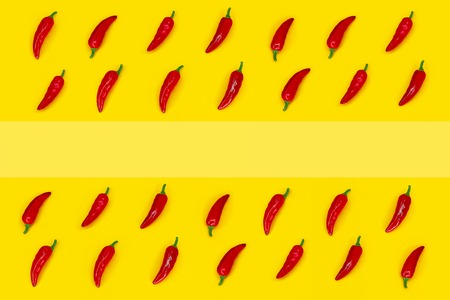Red chili pepper frame on a yellow background with copy space. Ingredient of Mexican Cuisine. Top view.の写真素材