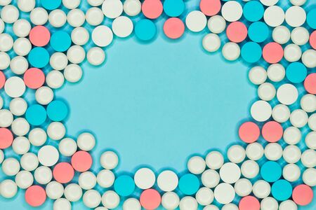 Round frame of white, blue and red pills on light blue background. Medical conceptの写真素材