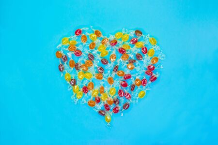 Multicolored heart shaped candies with colorful background. Top view.の写真素材
