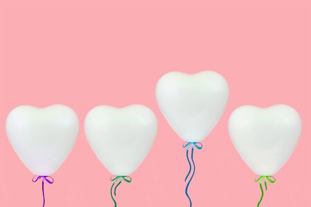 holidays, valentines day and party decoration concept - white heart shaped balloons over pastel coral pink background with copy spaceの写真素材