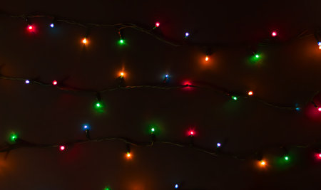 Glowing colorful Christmas lights on black backgroundの写真素材