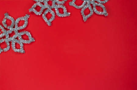 Frame made of silver snowflakes on a red background with copy space.