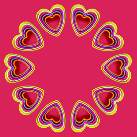 Round frame of colorful heart shaped cookie cutters on pink background, flat lay.の写真素材
