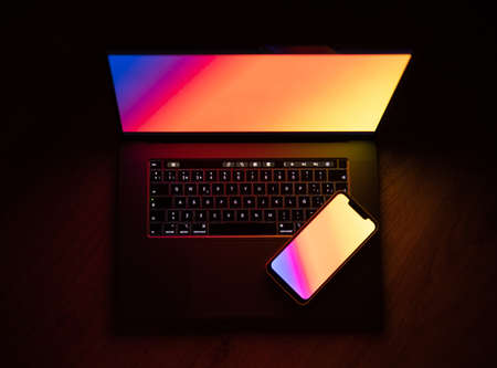 Open laptop with digital tablet and smartphone. Dark with colorfull technology.の写真素材