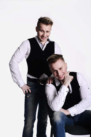 two twin brothers in gangster style posing. hats, vests, white shirts. white background.の写真素材