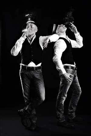 two twin brothers in gangster style posing. hats, vests, white shirts. white and black.の写真素材