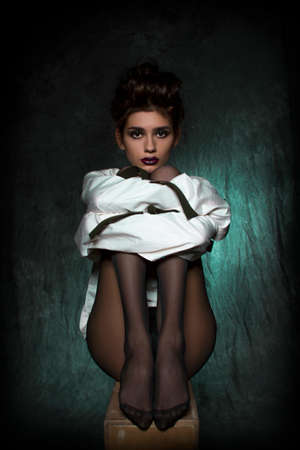 sexy girl with long legs in black tights and a white straitjacket.