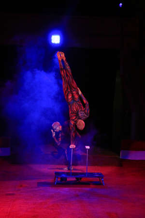 twins acrobats in neon costumes stand on their arms, ultraviolet makeupの写真素材