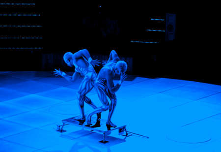 twins acrobats in neon costumes stand on their arms, ultraviolet makeupの写真素材