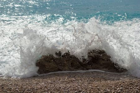 Closeup of a sea splash against a rockの写真素材