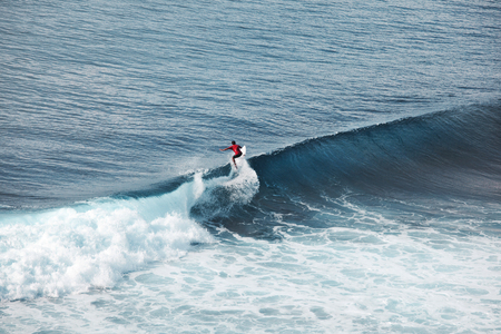 Surfer in ocean on big waves. Bali surfing aerial shot. water sports. Healthy Active Lifestyle....
